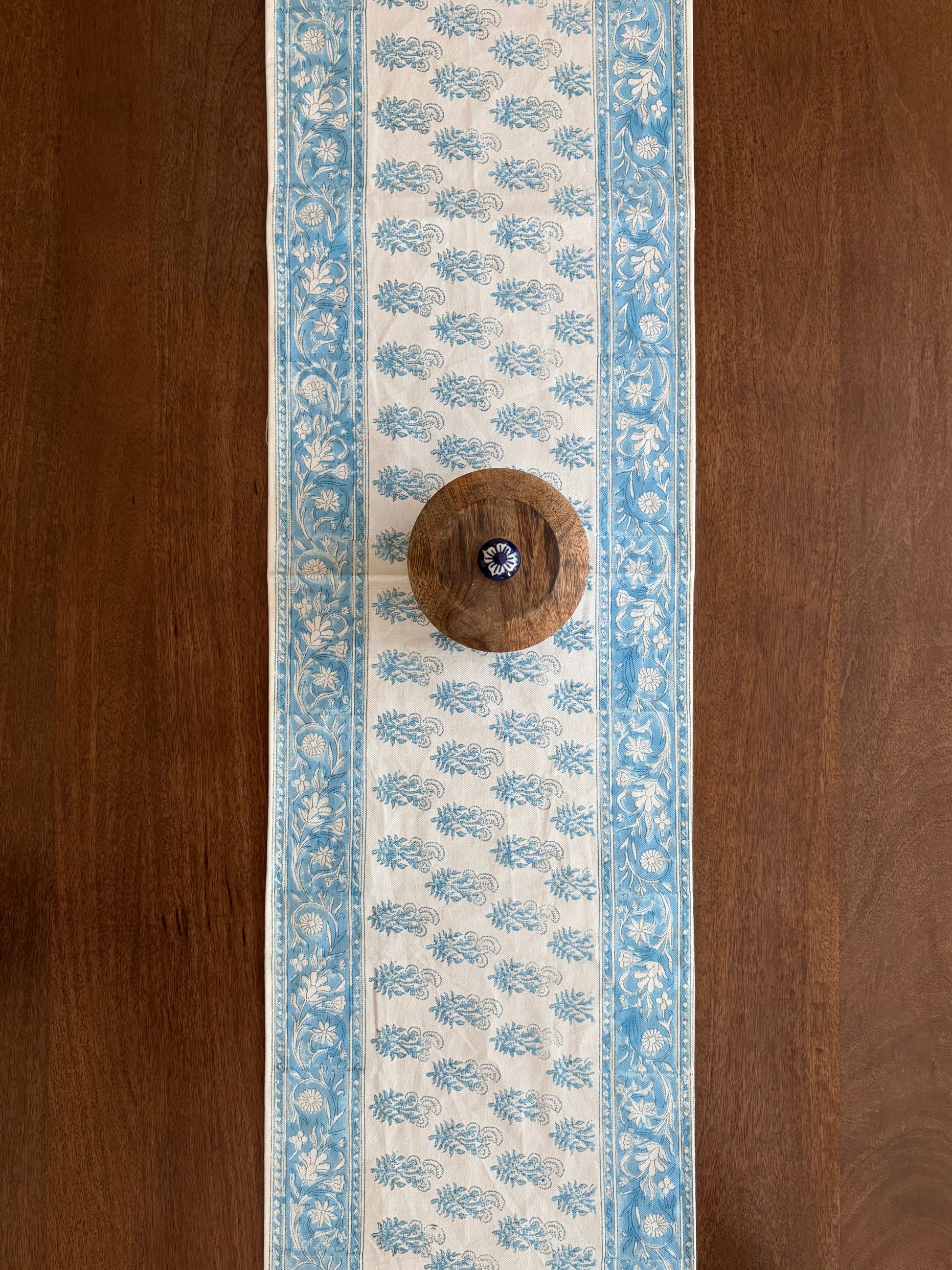 House of Mulmul - Cotton Blockprinted Table Runner. Decorative table runner with blue floral pattern on a wooden surface