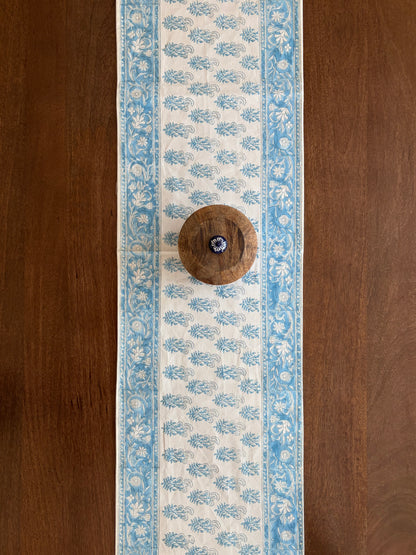 House of Mulmul - Cotton Blockprinted Table Runner. Decorative table runner with blue floral pattern on a wooden surface
