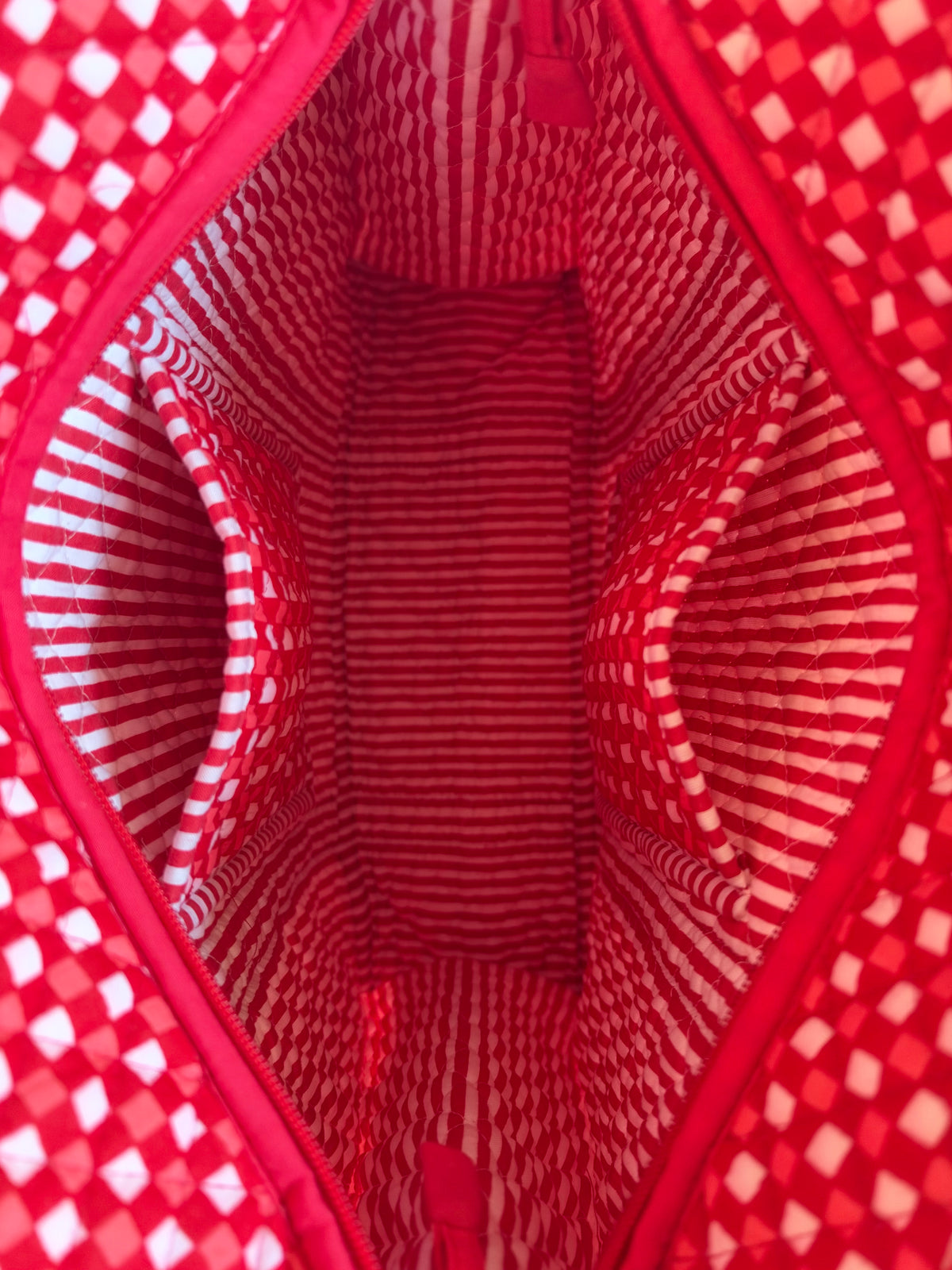 House of Mulmul - Cotton Tote Bags. Close-up of a red and white patterned bag interior with a zippered opening and two side pockets.