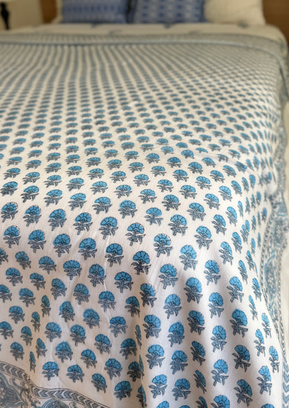 House of Mulmul - Coverlet Dohar blanket. Bedroom with reversible cotton coverlet blanket. Muslin dohar with boota paisley leaf and blue and grey colors, white background.