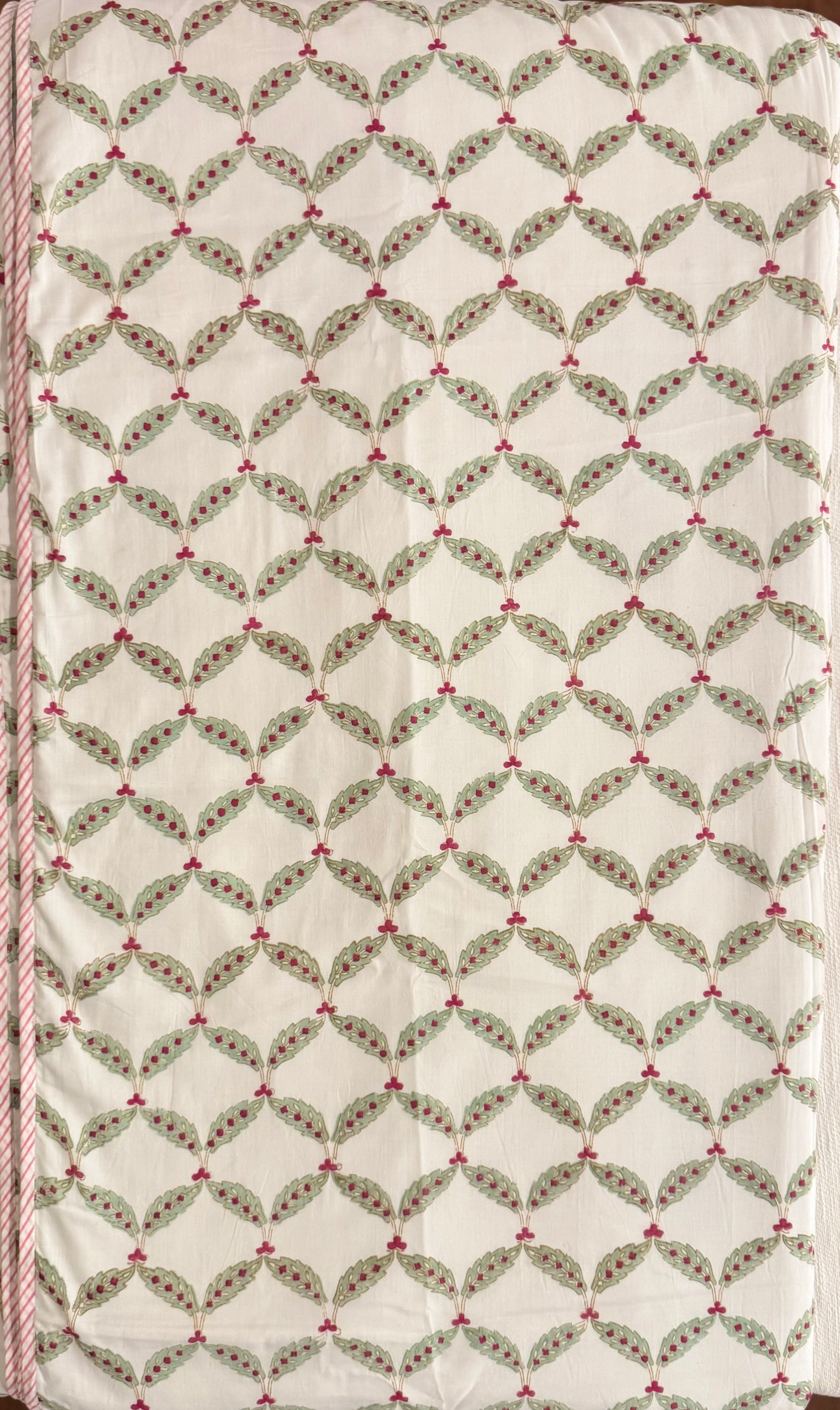 House of Mulmul - Coverlet Dohar, cotton blanket, muslin blanket, mulmul dohar. Decorative handblock printed fabric with patterned fabric with green leaves and red berries on a white background