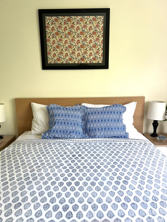 House of Mulmul - Cotton Coverlets (Dohar). Bedroom with blue and white patterned bedding, pillows, and a framed artwork on the wall.