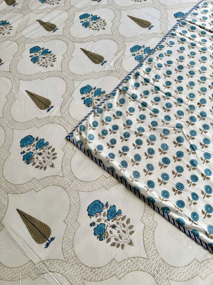 House of Mulmul - Coverlet Dohar blanket. Bedroom with reversible cotton coverlet blanket. Muslin dohar with palms cypress leaf and blue and brown colors, white background.