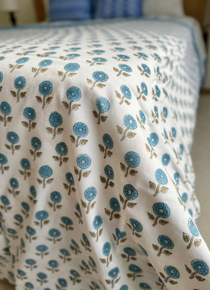 House of Mulmul - Coverlet Dohar blanket. Bedroom with reversible cotton coverlet blanket. Muslin dohar with palms cypress leaf and blue and brown colors, white background.