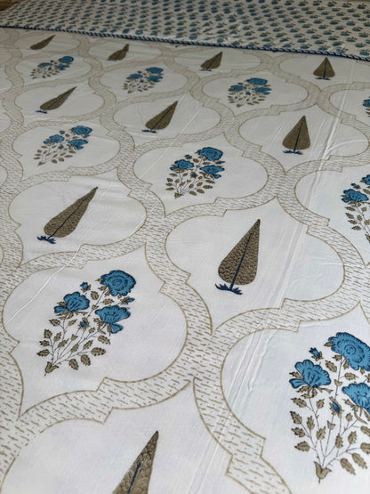 House of Mulmul - Coverlet Dohar blanket. Bedroom with reversible cotton coverlet blanket. Muslin dohar with palms cypress leaf and blue and brown colors, white background.