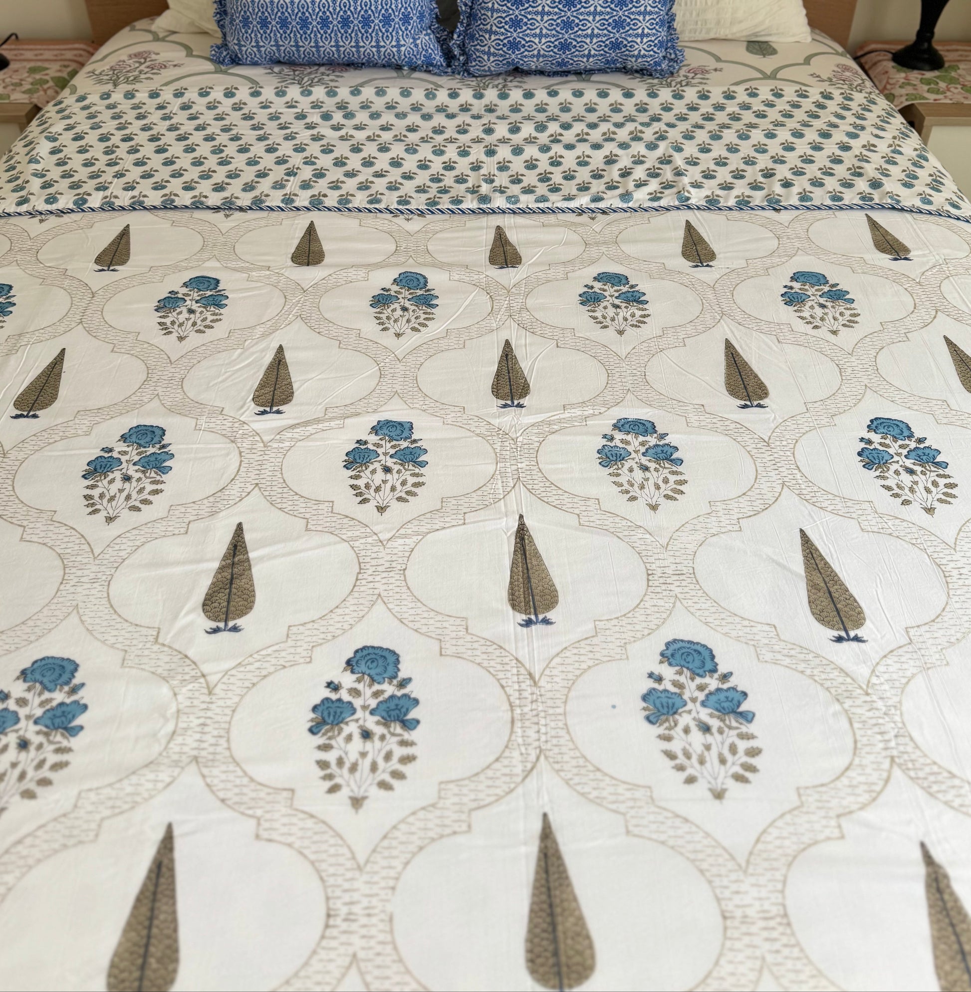 House of Mulmul - Coverlet Dohar blanket. Bedroom with reversible cotton coverlet blanket. Muslin dohar with palms cypress leaf and blue and brown colors, white background.