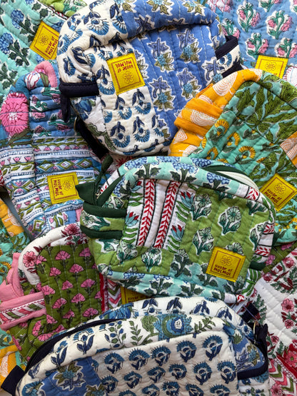 House of Mulmul - Handblock Printed Travel Makeup Quilted Pouch set. Collection of colorful patterned bags with visible brand tags on a floral background