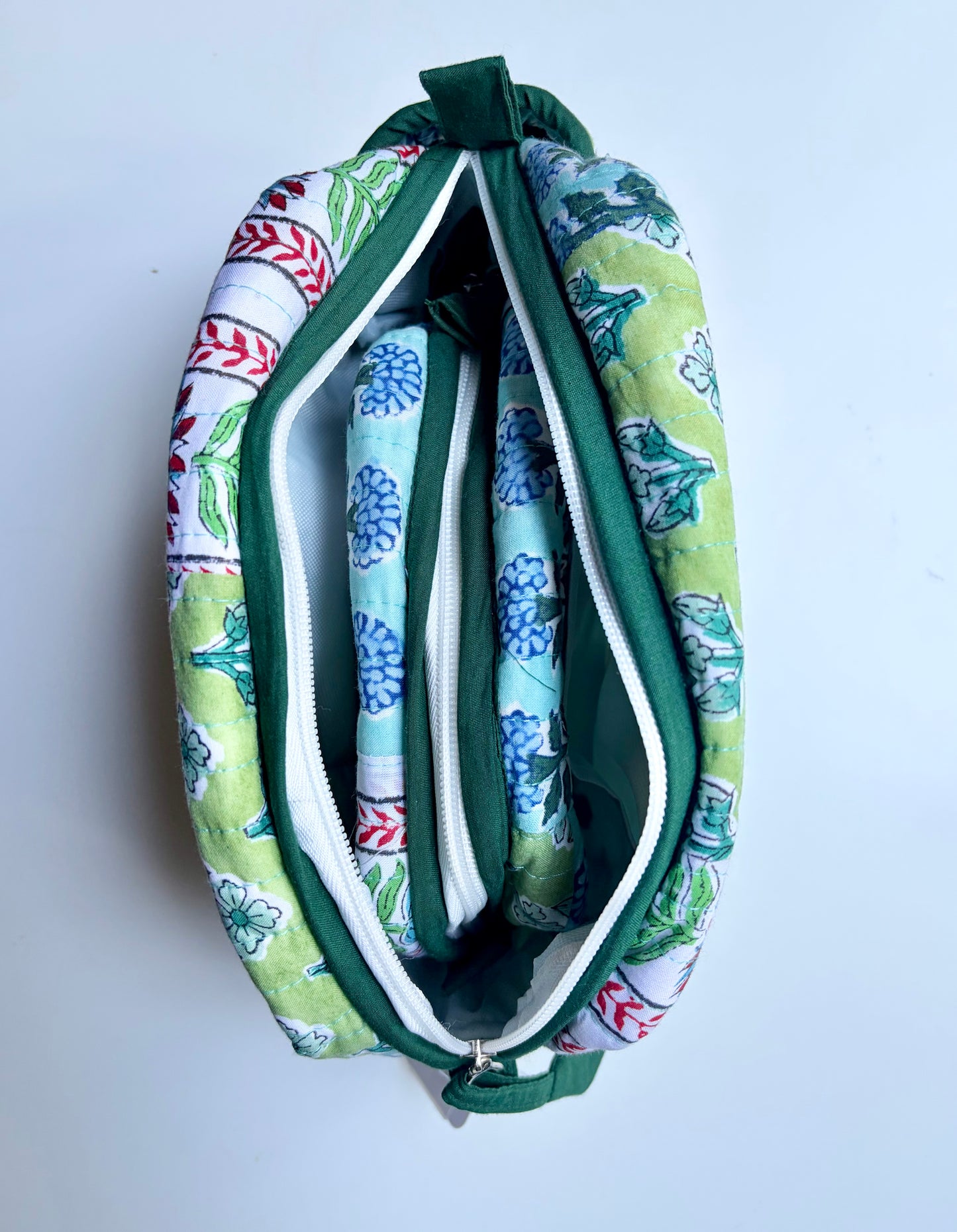 House of Mulmul - Handblock Printed Travel Makeup Quilted Pouch set. Floral-patterned pouch with a green zipper on a white background