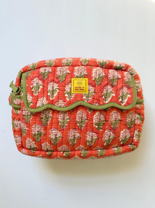 House of Mulmul - Handblock Printed Travel Makeup Quilted Pouch set. A quilted cosmetic pouch with a coral red background, a pink and green floral block print, and olive green scalloped trim. A yellow square label on the front flap reads 'House of Mulmul'.