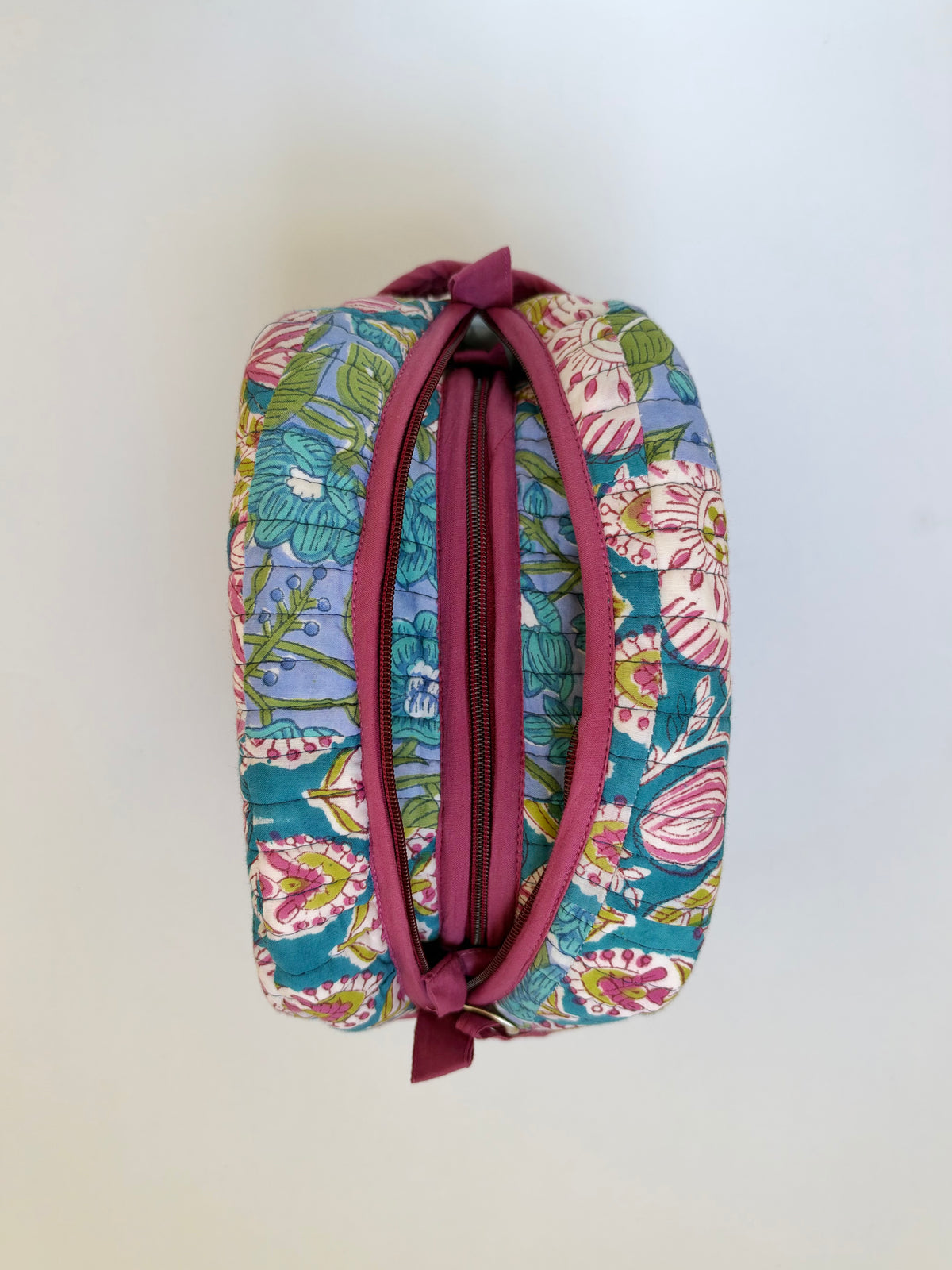House of Mulmul - Handblock Printed Travel Makeup Quilted Pouch set. A small zippered cosmetic pouch with a colorful floral print on a teal background and a dusty rose zipper, shown against a plain off-white background.