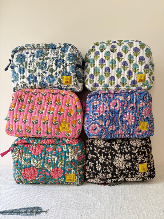 House of Mulmul - Quilted Blockprint Travel Makeup pouch. Stack of floral-patterned pouches with visible brand labels on a light background