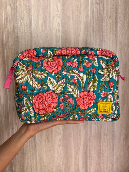 House of Mulmul - Quilted Blockprint Travel Makeup pouch. Green Pink Jade Floral patterned makeup bag held by a hand on a wooden surface.