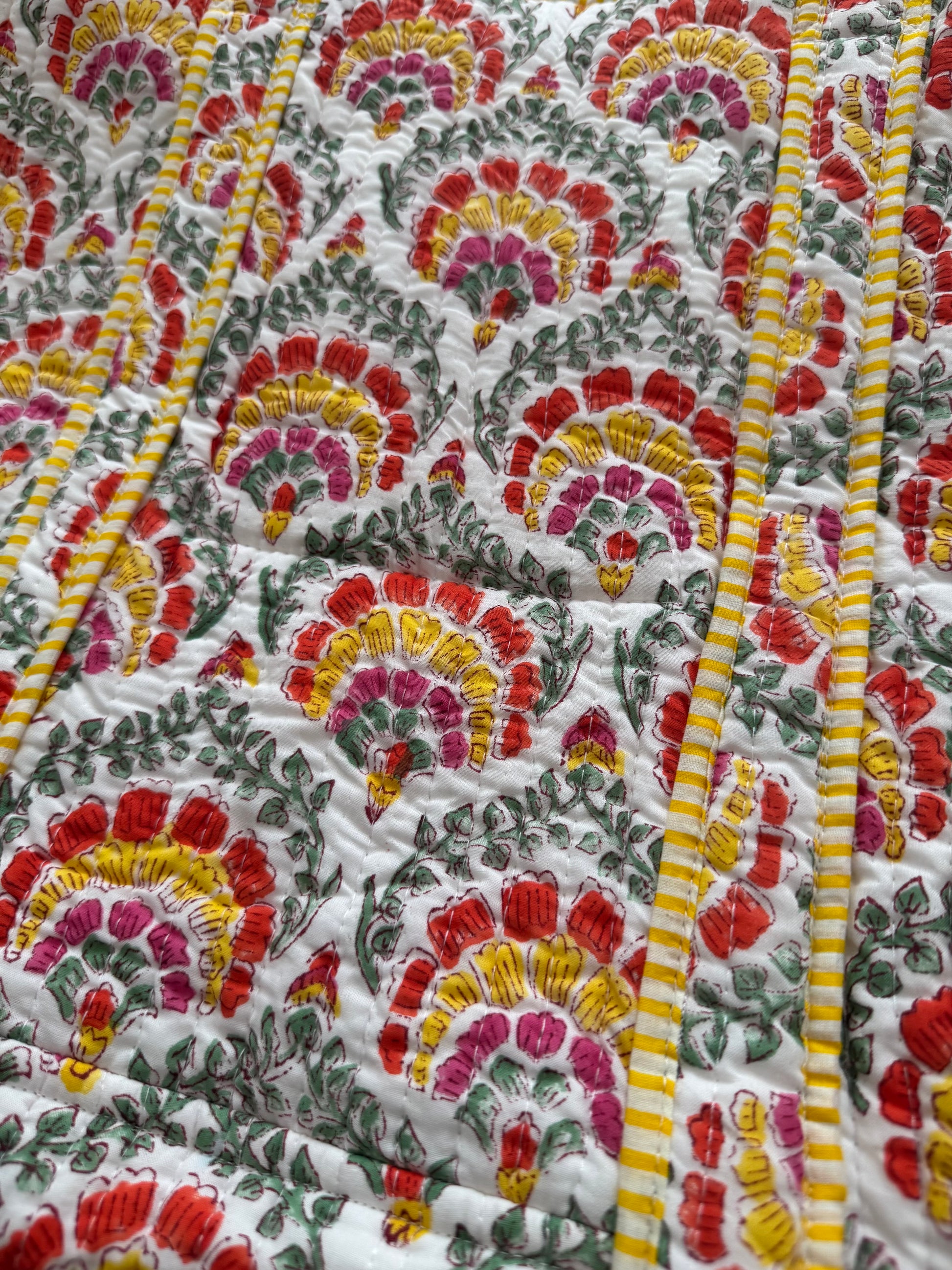 House of Mulmul - Cotton Tote Bag. Close-up of a colorful floral patterned fabric with red, yellow, and green colors.