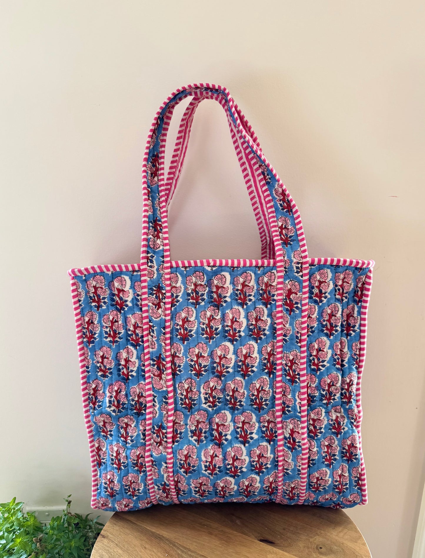 House of Mulmul - Cotton Tote Bag, Travel Bag. Tote bag with red and blue pattern on a wooden surface