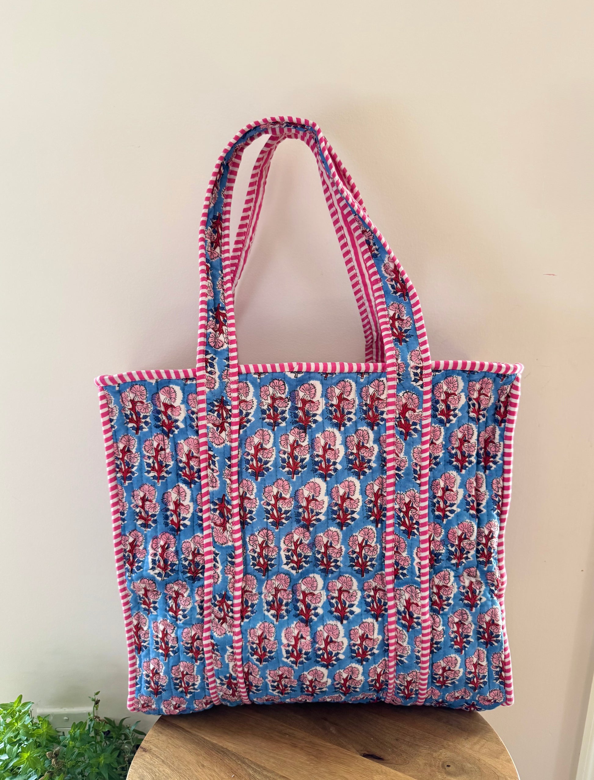 House of Mulmul - Cotton Tote Bag, Travel Bag. Tote bag with red and blue pattern on a wooden surface