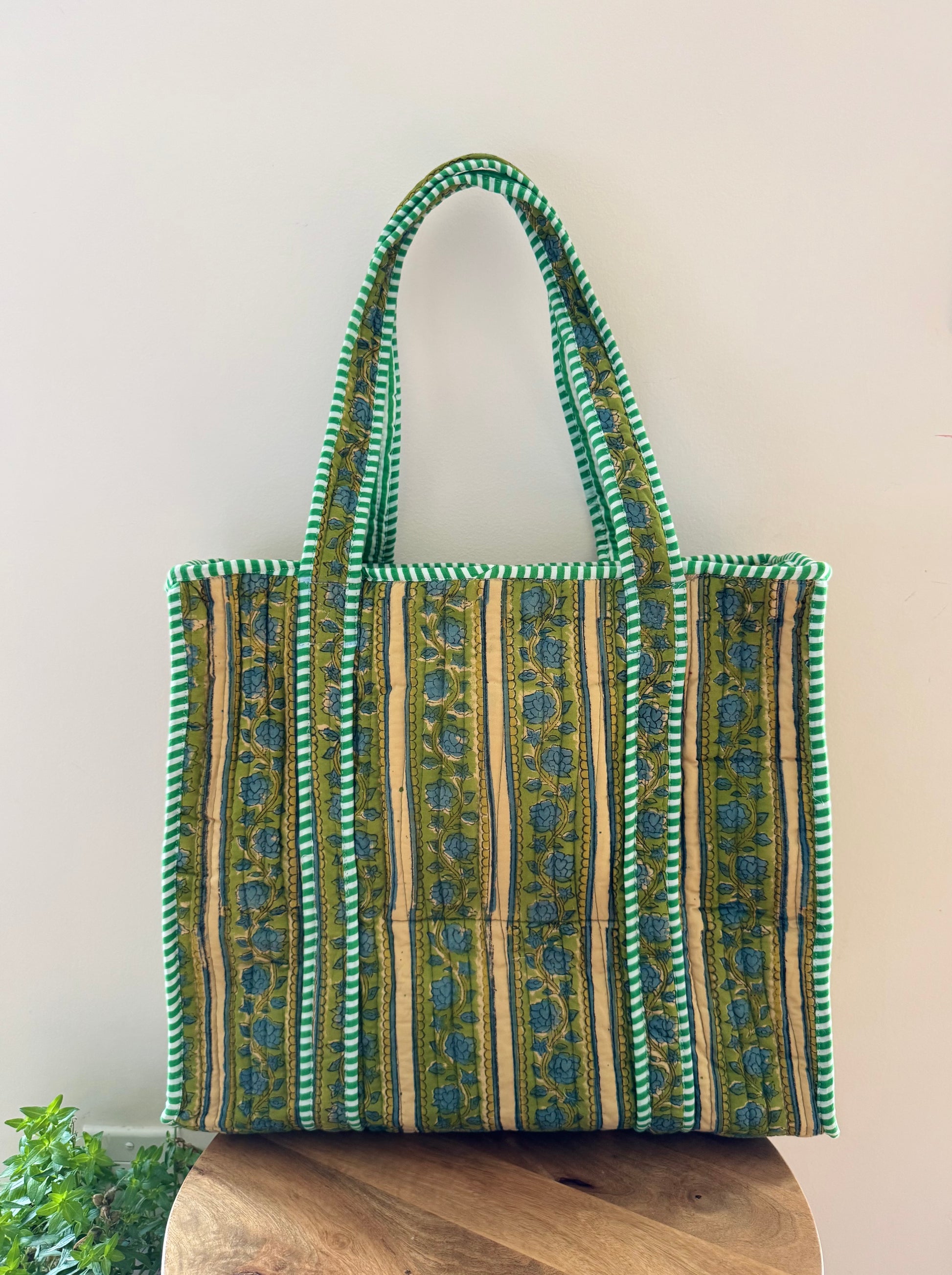 House of Mulmul - Cotton Tote Bag, Travel Bag. Green and beige patterned tote bag on a wooden surface with a light background
