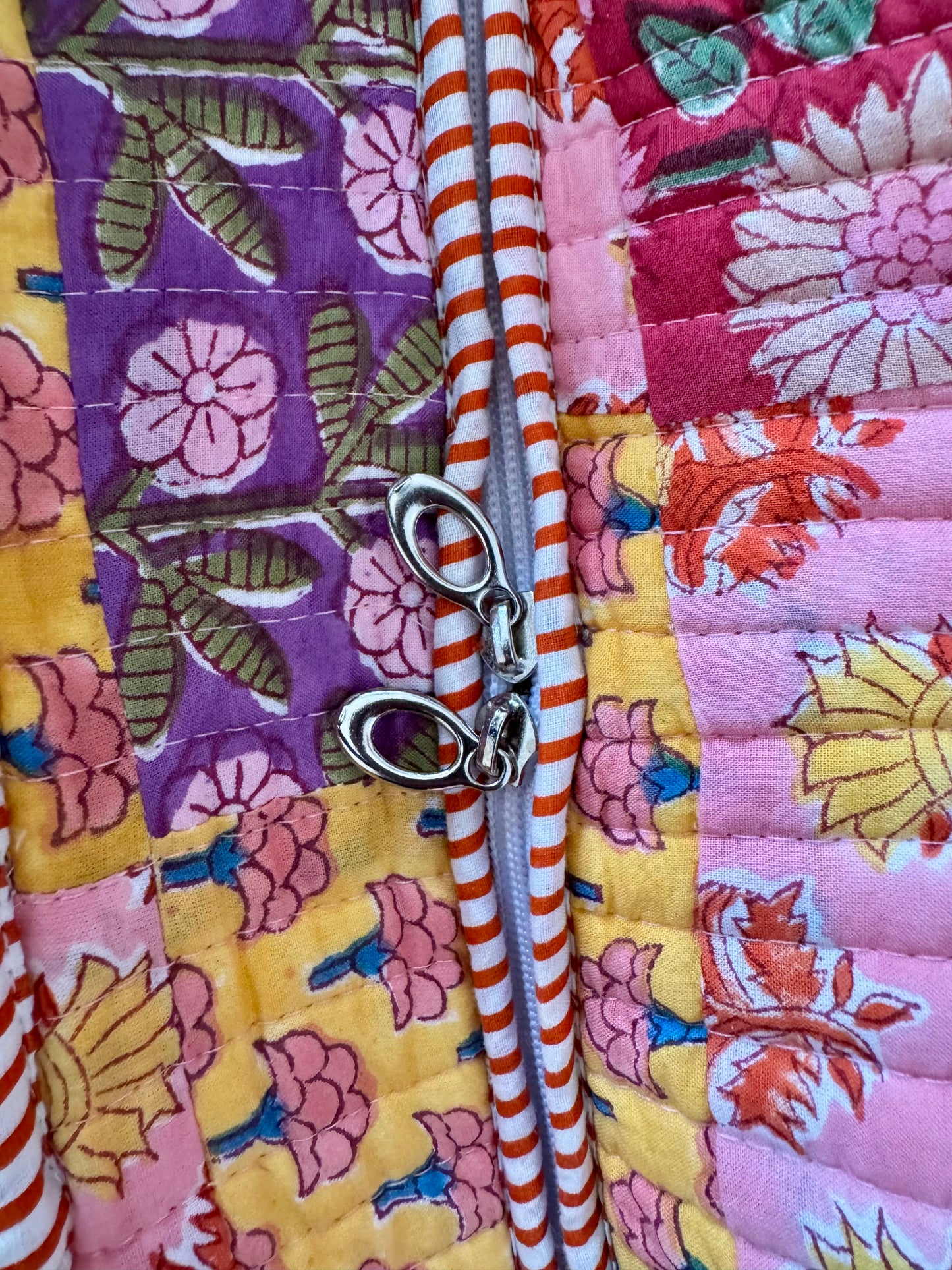 House of Mulmul - Cotton Tote Bag, Travel Bag. Close-up of a colorful fabric with a zipper and floral patterns