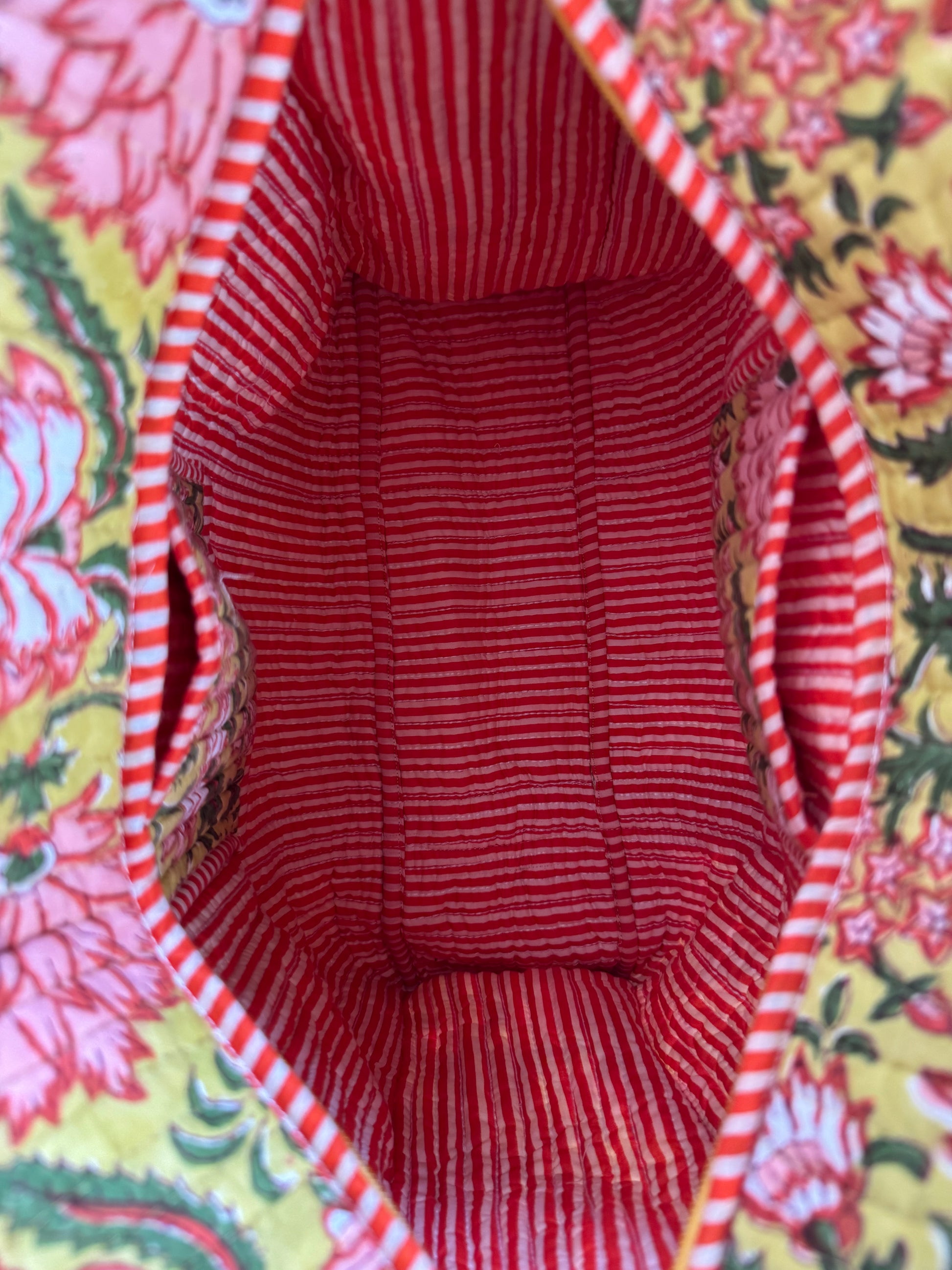 House of Mulmul - Cotton Tote Bag, Travel Bag. Close-up of a red and white striped fabric with pockets and floral patterned background