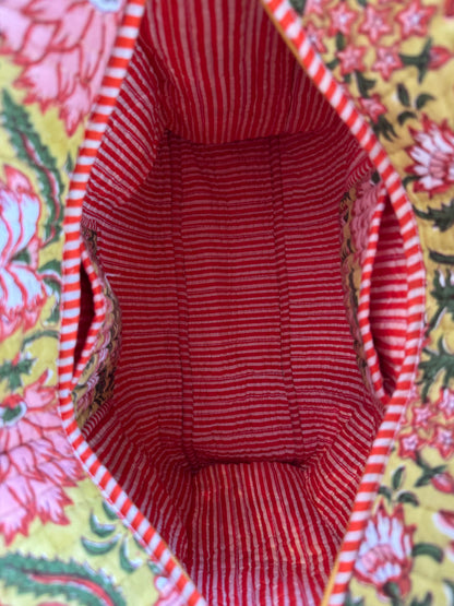 House of Mulmul - Cotton Tote Bag, Travel Bag. Close-up of a red and white striped fabric with pockets and floral patterned background