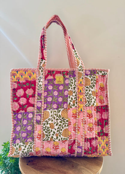 House of Mulmul - Cotton Tote Bag, Travel Bag. Colorful patchwork tote bag on a wooden surface with a white background