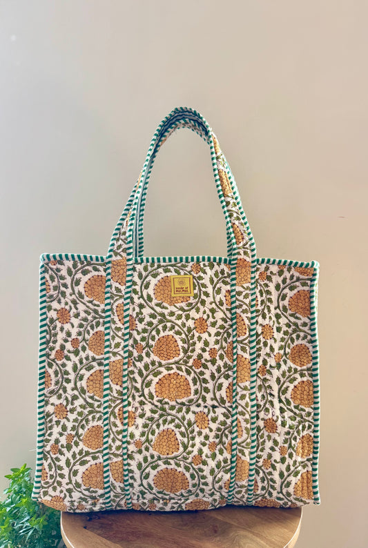 House of Mulmul - Cotton Tote Bag, Travel Bag. Floral patterned tote bag on a wooden surface with a plain background